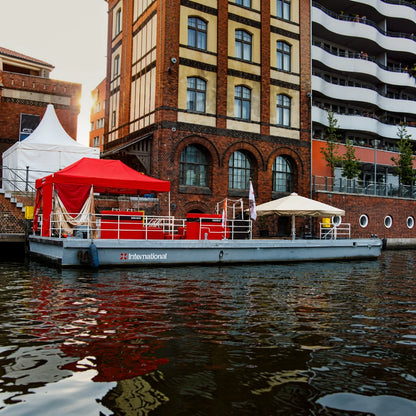 Vielseitige Veranstaltungsplattform auf dem Wasser mit Platz für bis zu 50 Personen und optionalem Shuttle-Service für Gäste und Personal.